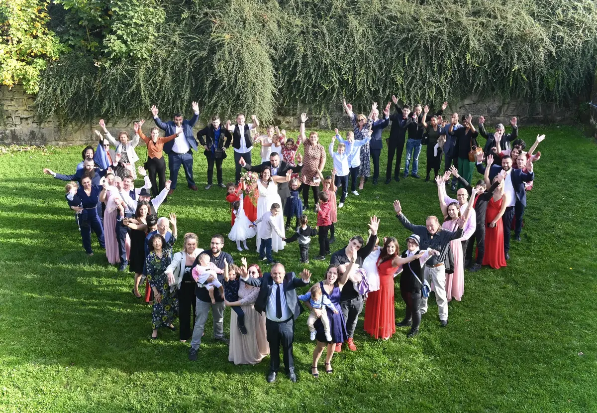 Invités d'un mariage formant un cœur sur la pelouse