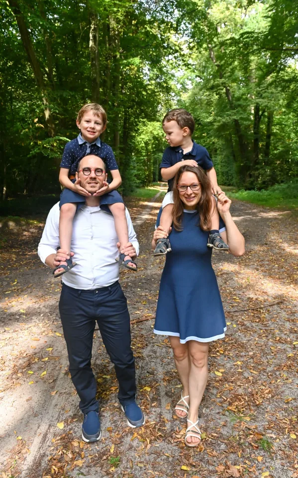 Parents portant leurs enfants sur les épaules en forêt