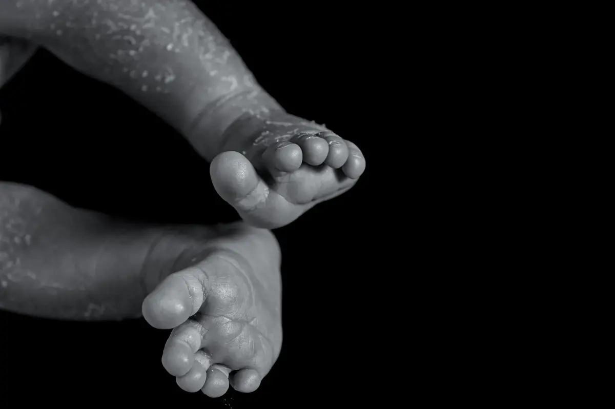 Pieds de nouveau-né dans les mains d'un parent